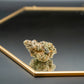 THCA cannabis buds on a reflective black surface with a gold rim